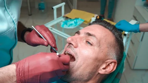 Dentist Checking Patient's Teeth Using Special Tool Stock Footage 107136260