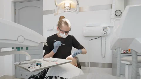 Dentist checking teenage boy bite with articulating paper and tweezers Stock Footage 330121791