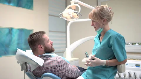 Dentist checking up teeth of patient and talking with him. Vídeos de archivo 68524652