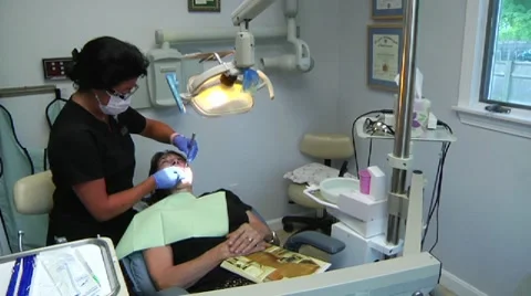 Dentist cleaning woman's teeth Stock Footage 8652504