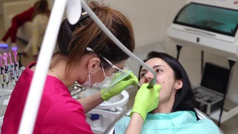Dentist cleans woman's teeth with professional toothpaste and automatic brush Stock Footage 74445504