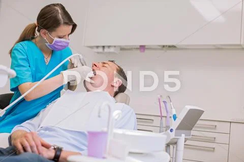 Dentist Conducting Dental Examination On Mature Man