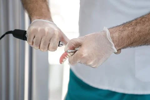 The dentist corrects the denture Stock Photos