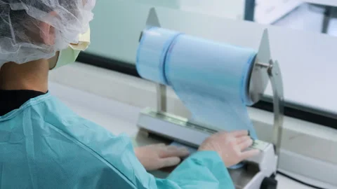 Dentist cuts off packaging for dental tools for disinfection, woman in focus Stock Footage 131684272