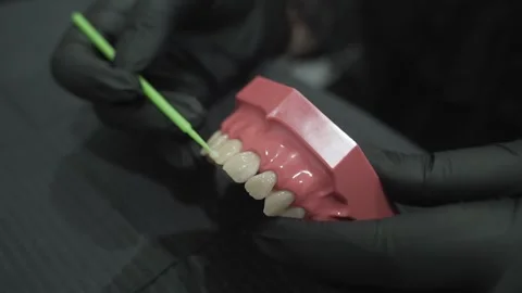 Dentist demonstrates flossing technique on model teeth, emphasizing dental Video stock 285435341
