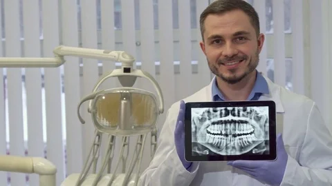 Dentist demonstrates the x-ray of human teeth on his tablet Stock Footage 73675905