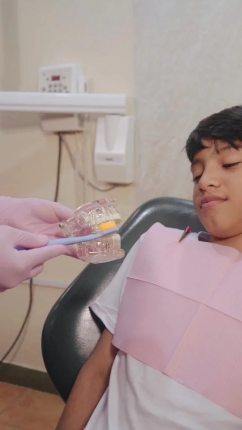 Dentist demonstrating tooth brushing technique to child patient Stock-Footage 346073201
