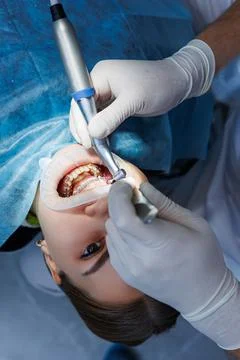 Dentist with dental instruments, examining patient's teeth in dental clinic o Stock-Fotos
