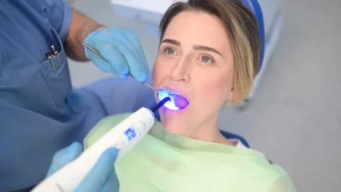 Dentist Fixes Braces with an Photopolymer Lamp in Dental Clinic