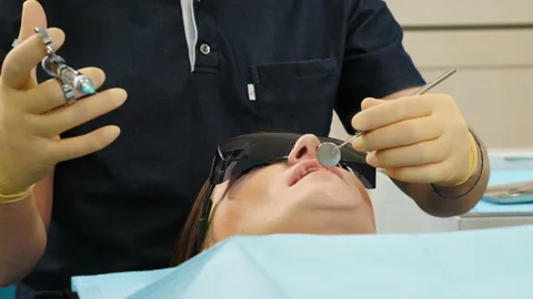 Dentist doing injection to his patient in dental clinic. Close up of Dentist Stock Footage 105144601
