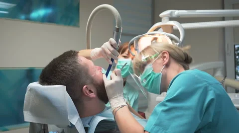 Dentist drilling man's tooth with the help of an assistant. Steadicam. Vidéo 68520773