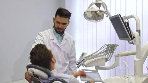 Dentist engages with patient while using advanced equipment Stock Footage 311952082
