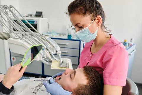 Dentist examines condition of teeth with help of dental mirror in patients Stock Photos