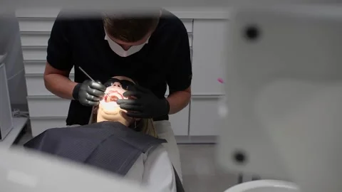 The dentist examines the patient's teeth Stock Footage 154021690