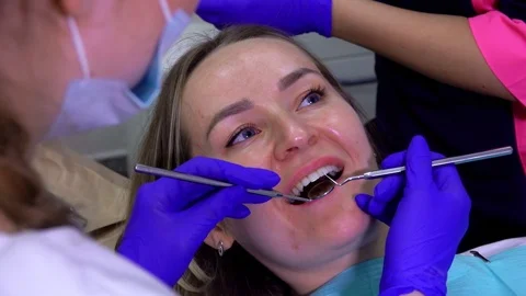 Dentist examines a patient's teeth with a mirror Stock Footage 115185027