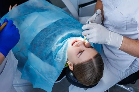 The dentist examines the patient's teeth using dental equipment. Modern medic 写真素材