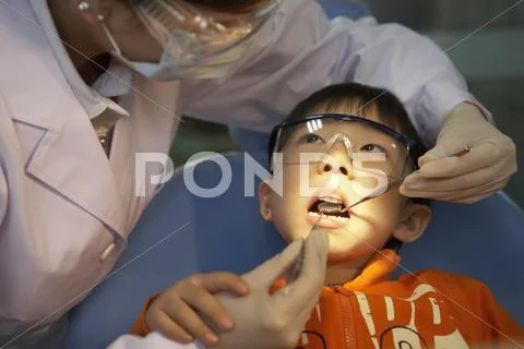 Dentist Examining Boy's Teeth