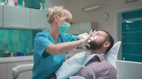 Dentist examining patient's teeth, explains him procedure. Steadicam. Vidéo 68717229