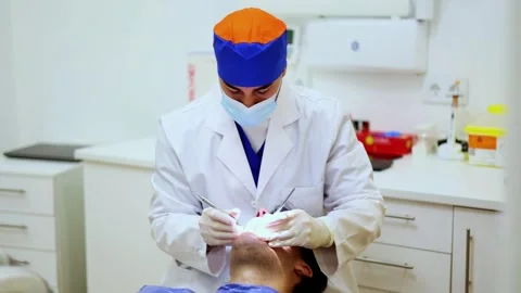 Dentist examining patient's teeth using dental tools Stock Footage 295626830