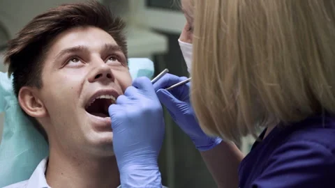 Dentist examining teeth with medical instruments. Portrait of man checking his Stock Footage 145010921