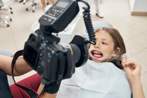Dentist examining teeth, using special equipment. Stock Photos