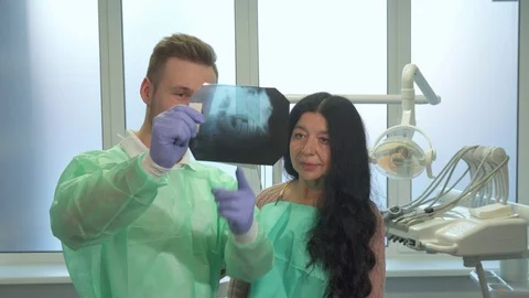 Dentist explaines to the patient something on x-ray Stock Footage 73576728