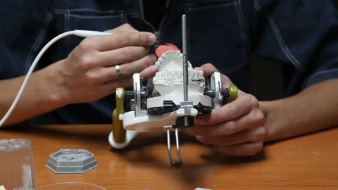 Dentist explaining artificial teeth to patient in clinic office. Stock Footage 87394753