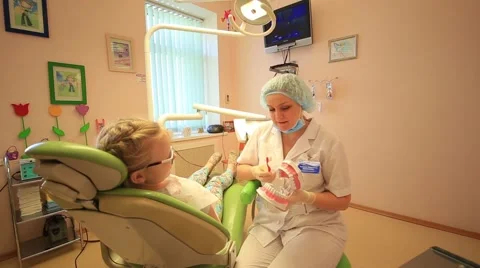 Dentist explaining to child how right brush your teeth Stock Footage 68492812