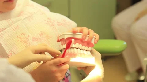 Dentist explaining to child how right brush your teeth Stock Footage 68496626