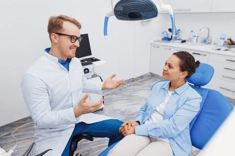 Dentist explaining client about dental procedure Stock Photos