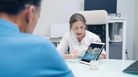 Dentist explaining dental treatment using digital tablet Stock Photos