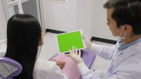 Dentist explaining procedure to patient from greenscreen tablet. Stock Footage 90825684