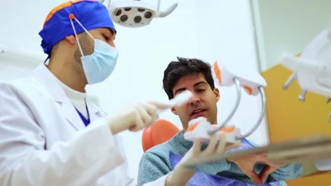 Dentist explaining teeth brushing using dental mold Stock Footage 295628100
