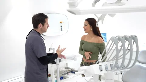 Dentist explaining treatment to patient in modern clinic Stock Footage 306061249