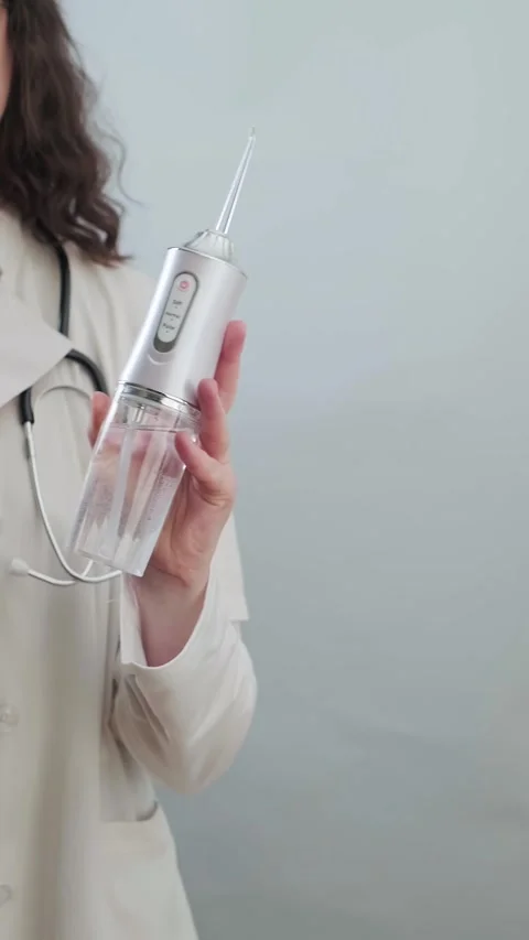 Dentist explains how an irrigator helps clean hard-to-reach areas between teeth Stock Footage 307302927