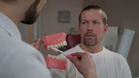 Dentist explains the man how to properly brush their teeth Video stock 61852429