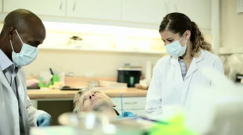 Dentist explains procedure to patient before beginning oral exam Stock Footage 54319661