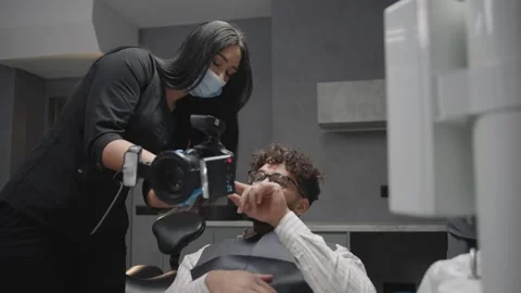 Dentist explains procedures to patient in clinic while showcasing tools Video stock 320875302