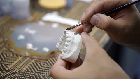 Dentist gently stains denture in lab Stock Footage 127237245