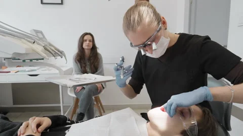 Dentist giving anesthesia injection to scared patient while mother waits Video stock 330121672
