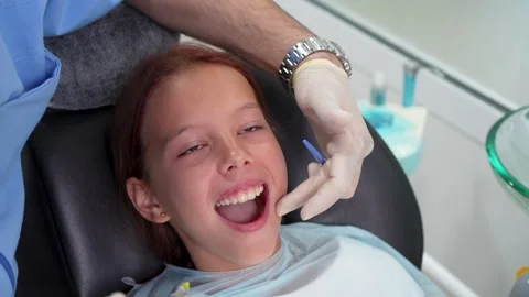 Dentist giving local anesthesia injection to little girl with dental carpul.. Stock Footage 339076680