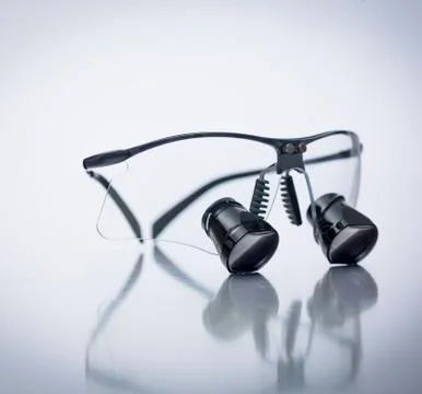 Dentist glasses on mirrored surface Stock Photos