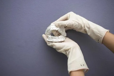 Dentist hand with plaster model Stock Photos
