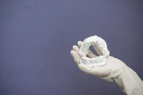 Dentist hand with plaster model Stock Photos
