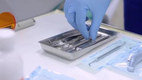 Dentist hands in blue gloves touching sterilized instruments Stock Footage 76240535
