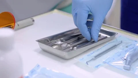 Dentist hands in blue gloves touching sterilized instruments Stock Footage 76240536