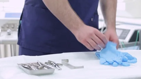 Dentist hands in blue gloves touching sterilized instruments Stock Footage 76240551