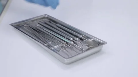 Dentist hands in blue gloves touching sterilized instruments Stock Footage 76240554