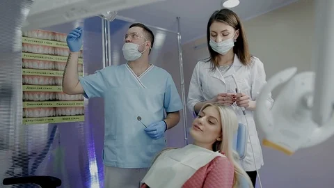 Dentist with his assistent before treatment the teeth of female patient in Stock Footage 104349435