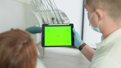 Dentist holding a digital tablet with a green screen in a modern dental clinic Stock Footage 341032871